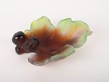 une figurine représentant un oiseau perché sur une feuille