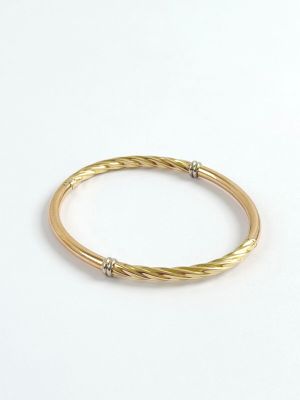 a close up of a gold bang with two diamonds on it