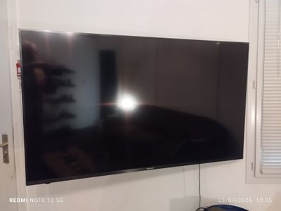 un téléviseur à écran plat accroché au mur d'une pièce