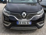 une voiture noire garée sur un parking à côté d'une caravane