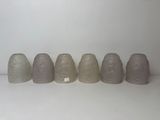several vases are lined up in a row on a white surface