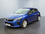 Une voiture bleue est garée dans une pièce au sol noir.