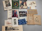 une image représentant une collection de livres anciens et de dessins posés sur une table