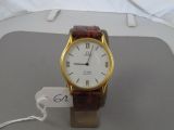 a gold wrist watch with a white face on a table