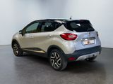 the rear end of a silver and black car in a white room