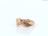 gros plan d'une bague en or avec des diamants sur une surface blanche