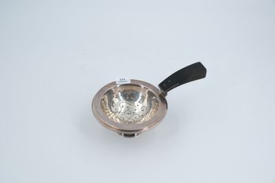 a small silver bowl with a black handle on a white surface