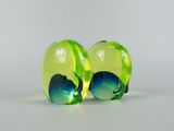 two green and blue glass balls sitting next to each other