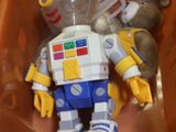 un robot jouet dans une boîte en plastique contenant un ours en peluche