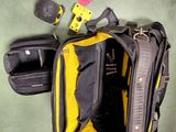 un sac jaune et noir posé par terre à côté d'une paire de chaussures