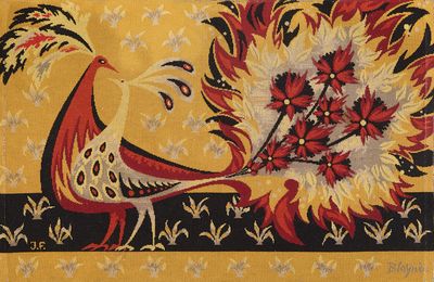 un tapis jaune et rouge orné d'un oiseau et de fleurs