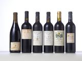 six bottles of wine are lined up on a table