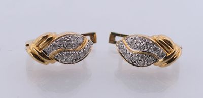 une paire de boucles d'oreilles en or et diamants sur fond blanc