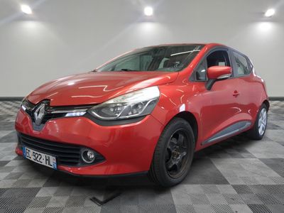 une voiture rouge est garée sur le sol en damier d'un garage