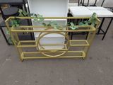 a gold metal shelf with a plant on top of it