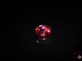 a close up of a pink diamond on a black surface