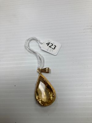 un collier en or auquel est suspendu, sur le côté, un pendentif en forme de larme