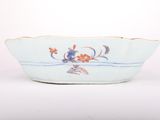 a blue and white bowl with flowers and leaves on it