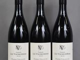 three bottles of red wine are lined up on a table