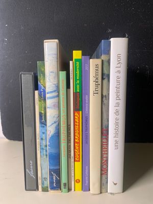 une pile de livres posée sur une table à côté d'une valise noire