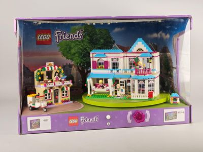 une boîte contenant un ensemble Lego Friends avec une maison de poupées à l'intérieur