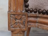 a close up of a wooden chair with a beaded seat