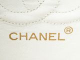 chanel logo on a white leather sneaker with gold trim