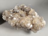 quartz crystal cluster on clear acrylic stand on white surface