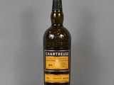 La bouteille de Chartreuse est posée sur une table en verre.
