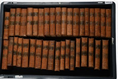 de nombreux livres anciens dans un coffret noir posé sur une table