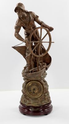 statue représentant un homme sur un bateau, avec un gouvernail et une horloge