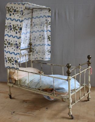 a small bed with a canopy over it on a wooden floor