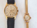 two watches sitting next to each other on a white surface