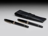 a pair of pens and a case sitting on top of a table