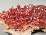 a piece of rock that has a lot of red crystals on it