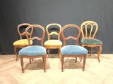 four chairs are lined up in a row on a wooden floor