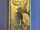 two gold bars sitting next to each other on a blue surface