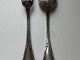 two spoons and a fork sitting on a table