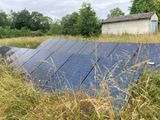 un panneau solaire au milieu d'un champ d'herbes hautes