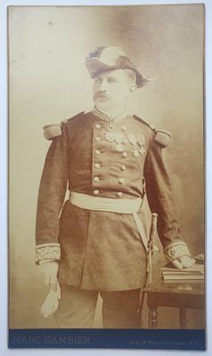 une vieille photo d'un homme en uniforme militaire debout devant une table