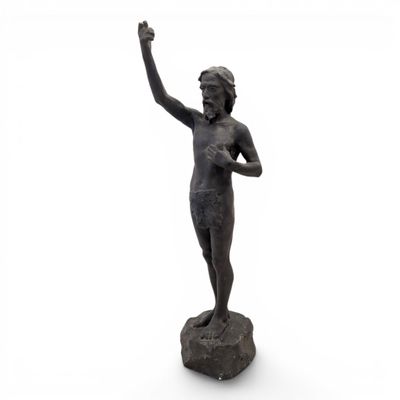 statue of a boy with a raised hand on a rock