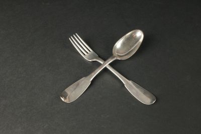 deux cuillères et une fourchette posées sur une table noire