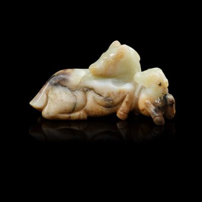 un petit animal sculpté, couché sur une surface noire