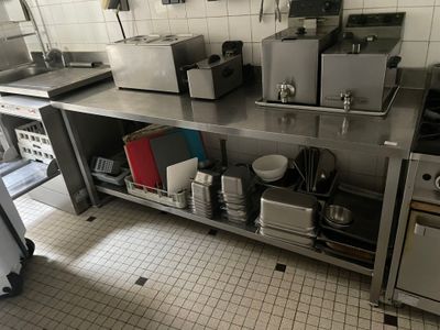 une cuisine avec de nombreux appareils électroménagers posés sur le plan de travail