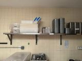 a kitchen with a lot of pots and pans on the shelves