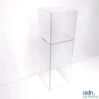 une vitrine transparente avec un couvercle en verre, posée sur un plan de travail blanc