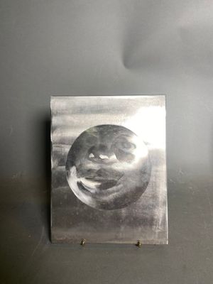 a metal plaque with a face on it on the wall