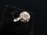 a close up of a diamond ring on a black velvet surface