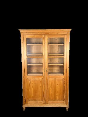 une photo d'une bibliothèque en bois avec des portes vitrées et des étagères