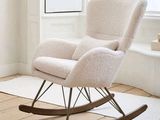un fauteuil à bascule blanc dans une pièce où se trouve un tapis blanc